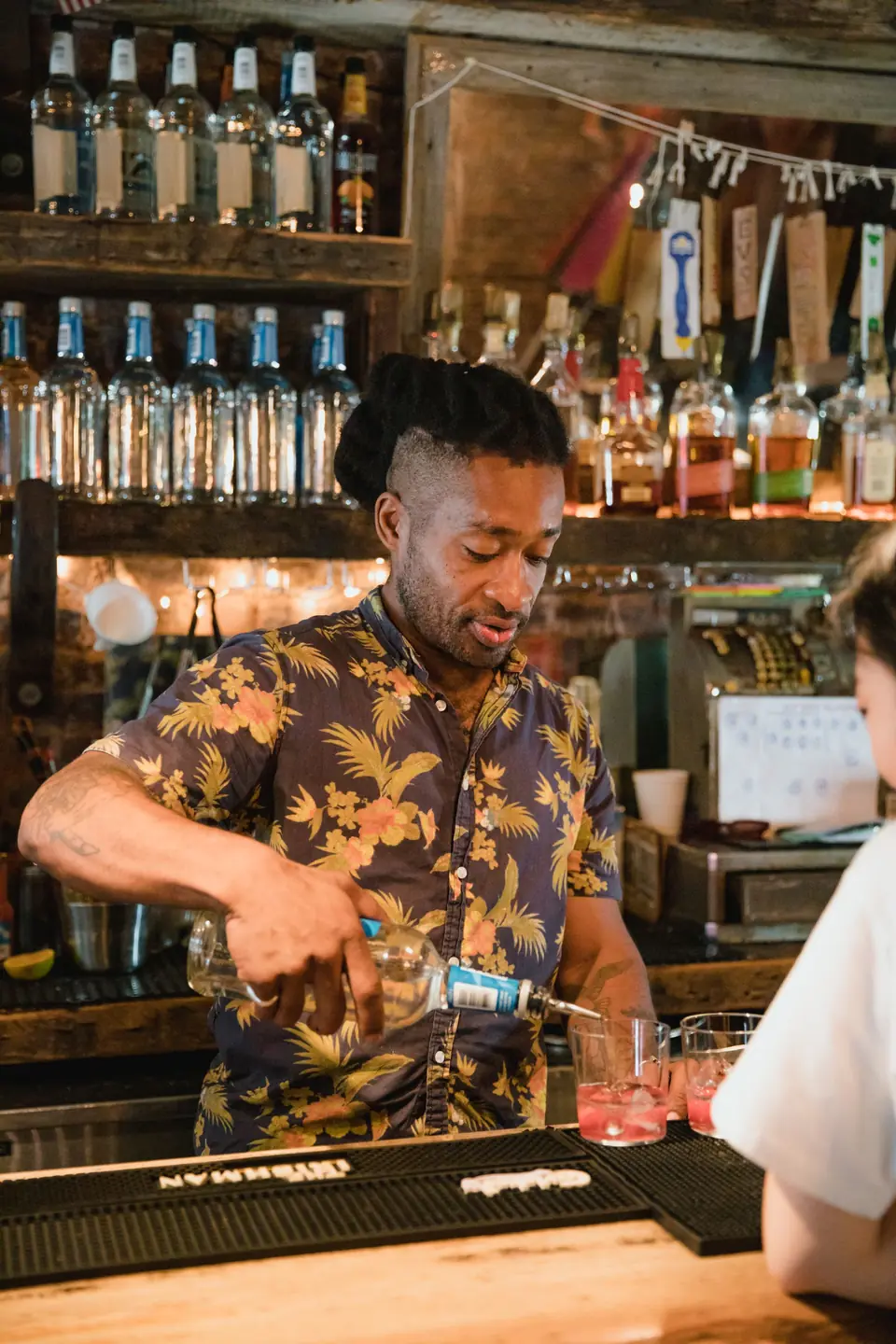 Barkeeper schenkt an der Bar ein Getränk ein